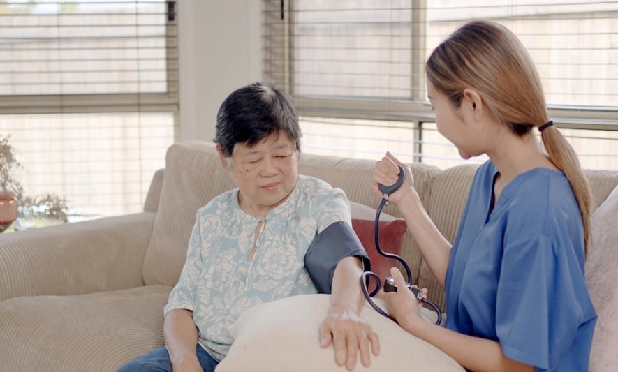 Aged care worker checks a patient's blood pressure