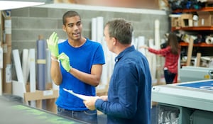 Image of a worker and boss in a print shop