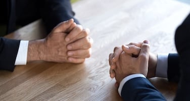 two employees with hands on table