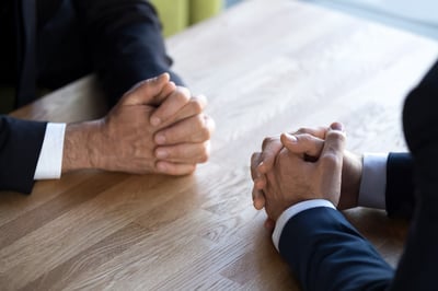 two employees with hands on table